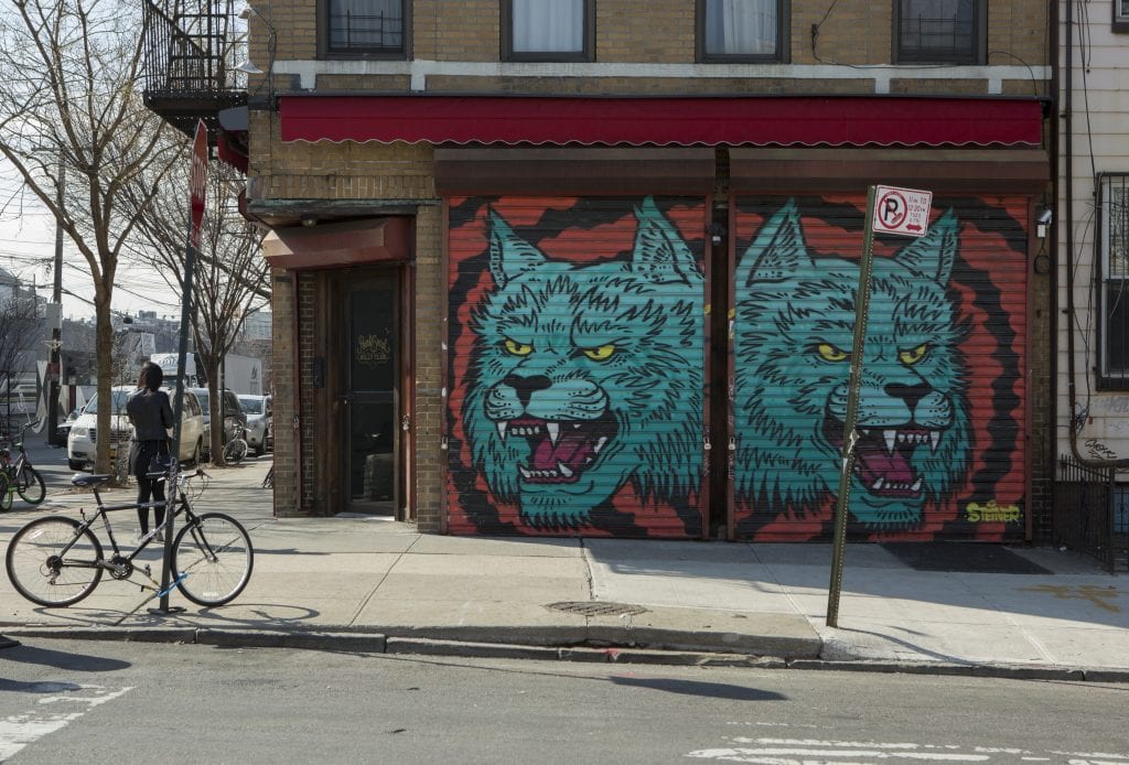 Corner street art of two blue wolf heads from artist Steiner on Starr Street in Bushwick